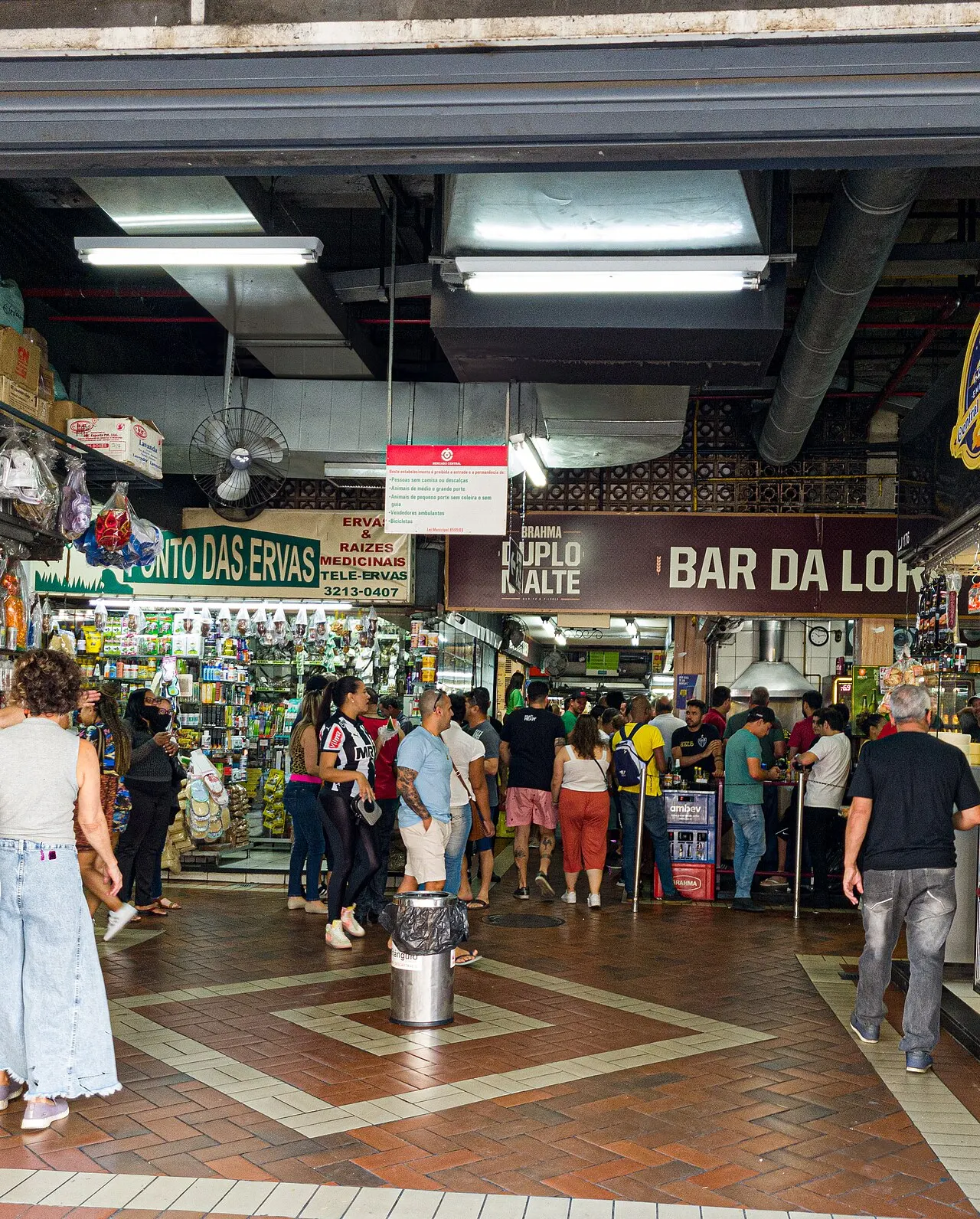 Entrada do Mercado Central de Belo Horizonte, com lojas e movimento de pessoas